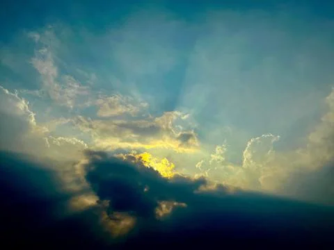 Dramatic stormy sky with golden sunlight breaking through dark clouds Foto stock