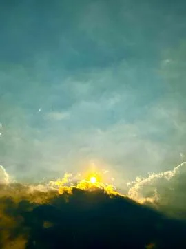 Dramatic stormy sky with golden sunlight breaking through dark clouds Stock Photos