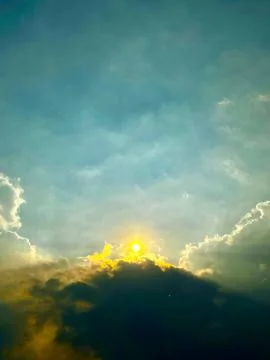 Dramatic stormy sky with golden sunlight breaking through dark clouds Stock Photos