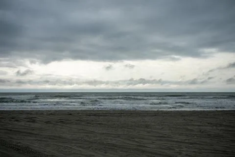 A Dramatic Stormy Sky Over a Dark Beach Stock Photos