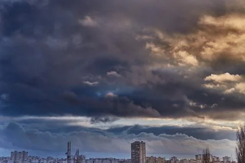 Dramatic stormy sky over a gray city, storm clouds over the city, the beginni Stock Photos