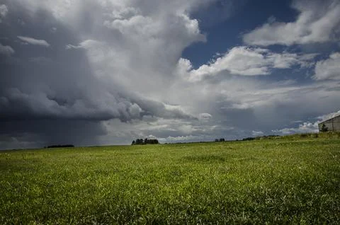  Dramatic stormy sky over green meadow. Nature composition. Stock Photos