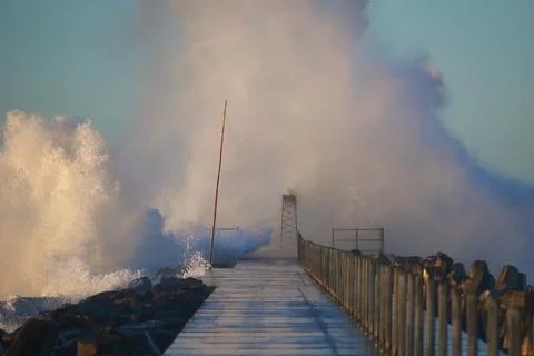 Dramatic, strong waves and foam spray hit the pier on the North Sea coast Foto stock