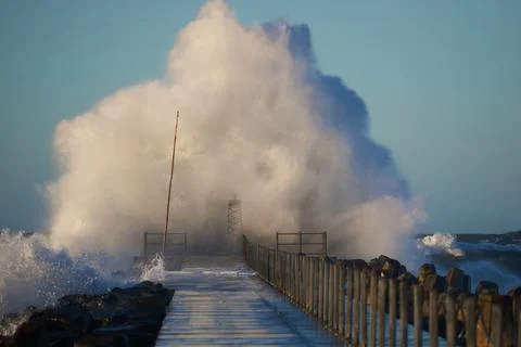 Dramatic, strong waves and foam spray hit the pier on the North Sea coast Foto stock
