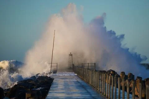 Dramatic, strong waves and foam spray hit the pier on the North Sea coast Foto stock