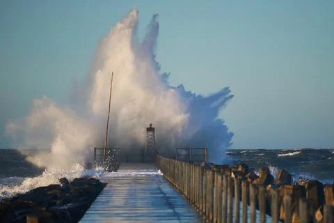 Dramatic, strong waves and foam spray hit the pier on the North Sea coast Foto stock