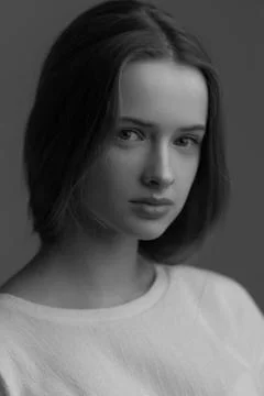 Dramatic studio portrait of a beautiful dreamy girl. Monochrome image. Stock Photos