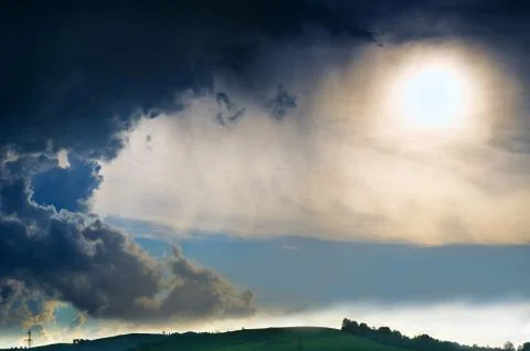 Dramatic Summer Thunderstorm Clouds with Distant Rain Shower and Blurred Sun Stock Photos
