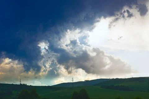 Dramatic Summer Thunderstorm Clouds Over Green Hills, Trees, Power Lines on S Stock Photos