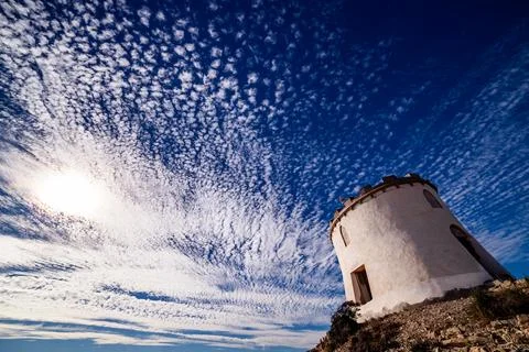Dramatic Sun Flare and Altocumulus Sky Above the Watchtower Stock Photos