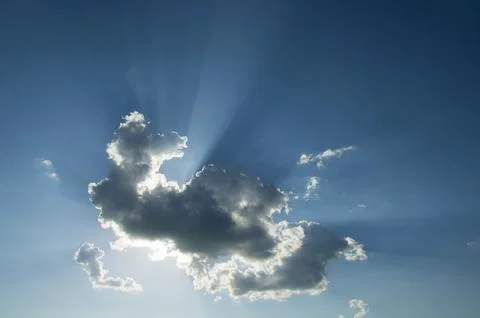 Dramatic Sun Rays Behind Dark Clouds in Blue Sky Foto stock