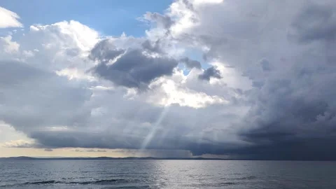 Dramatic Sun Rays Breaking Through Dark Clouds Over the Sea Horizon Stock Footage 322821339