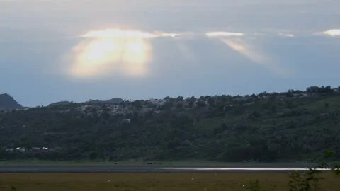 Dramatic Sun Rays Breaking Through Clouds Over Green Hills At Sunset Stock Footage 340500670