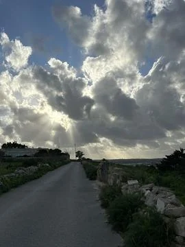 Dramatic sun rays breaking through heavy clouds Stock Photos
