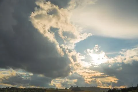 Dramatic Sun Rays Breaking Through Dark Cumulus Storm Clouds Stock Photos