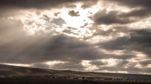 Dramatic sun rays dancing over windmills in a timelapse video Stock Footage 130931348