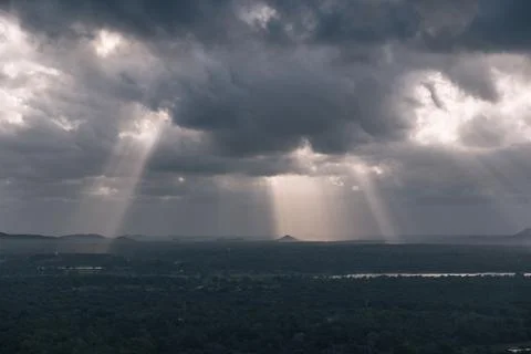 Dramatic sun rays filtering through dark clouds Foto stock