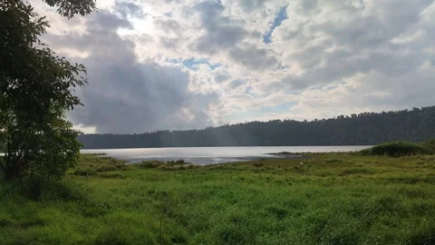 Dramatic Sun Rays Shining Over Calm Lake and Green Meadow 스톡 동영상 339349606