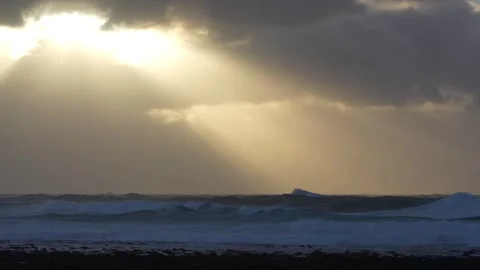 Dramatic sun rays through the clouds over a rough sea in 4k Video stock 292683144