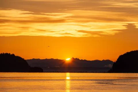 Dramatic sun rising between two hills with water Fotos Stock