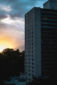 Dramatic sunbeams behind the Residential Building With Reflections in a Windows Stock Photos