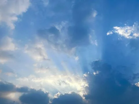 Dramatic Sunbeams Breaking Through Dark Clouds in a Blue Sky Concept of Hope Stock-Fotos