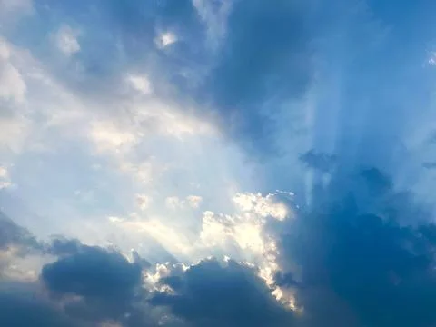 Dramatic Sunbeams Breaking Through Dark Clouds in a Blue Sky Concept of Hope Foto stock