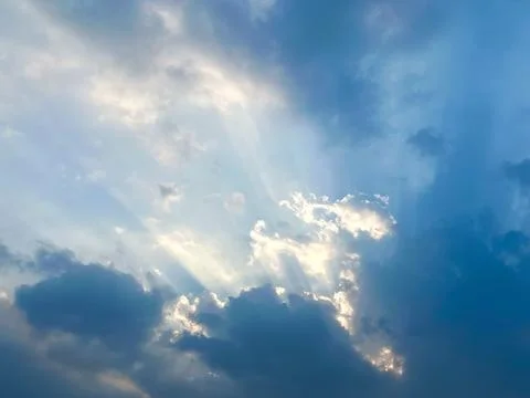 Dramatic Sunbeams Breaking Through Dark Clouds in a Blue Sky Concept of Hope Foto stock