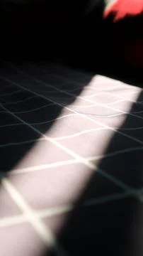 Dramatic sunlight on dark checkered fabric background Stock Photos