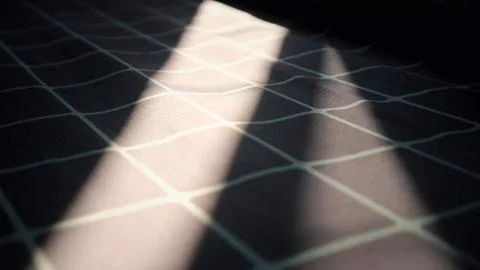 Dramatic sunlight on dark checkered fabric background Stock Photos