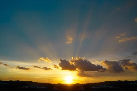 Dramatic sunlight or sun ray through the clouds at sunset sky background . Stock Photos