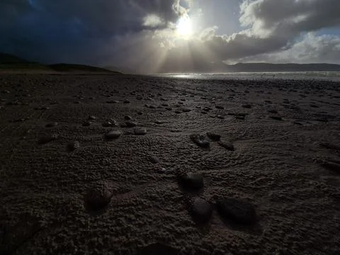 Dramatic Sunlight Over Rocky Beach at Low Tide Stock Photos