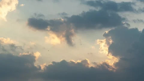 Dramatic sunlight pierces through white clouds in a beautiful blue summer sky Stock Footage 325857064