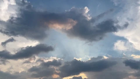 Dramatic Sunlight Piercing Through Dark Clouds in a Blue Cinematic Sky Stock Footage 341035742