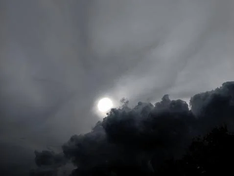 Dramatic Sunlight Piercing Through Dark Storm Clouds in the Sky Stock Photos