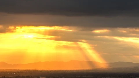 Dramatic sunrays through clouds over busy valley Vídeos de archivo 89819775