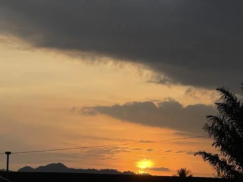 Dramatic Sunrise with Dark Clouds and Golden Horizon Foto stock
