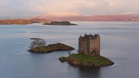 Dramatic sunrise lighting up castle stalker in scotland 库存影片 334060814