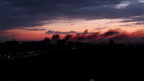 Dramatic sunrise over city with thick smoke from missile strike Stock Footage 339299475