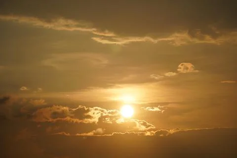 Dramatic sunrise over ocean waves with golden light and scattered clouds at d Stock Photos