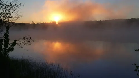 Dramatic sunrise over river. Golden sun pokes through purple fog Stock Footage 144417218
