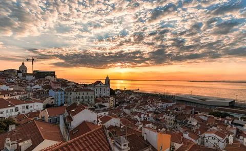 Dramatic sunrise over the rooftops of old district Alfama, Lisbon, Portugal Stock Photos