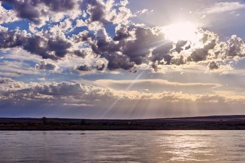 Dramatic sunrise over a steppe river with a calm current Stock Photos