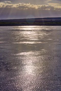 Dramatic sunrise over a steppe river with a calm current Stock Photos