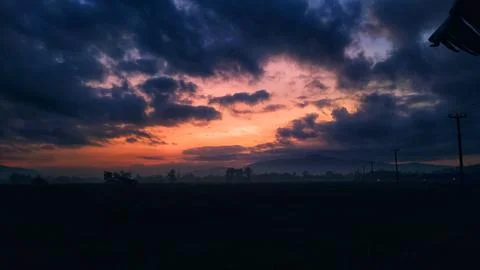 Dramatic Sunrise Sky with Orange Clouds over Countryside Field Silhouette Stock Photos