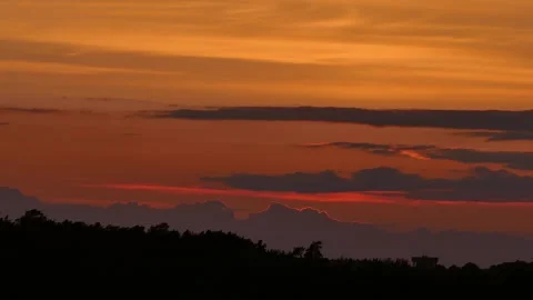 Dramatic sunrise timelapse with glowing orange clouds drifting across the sky Stock Footage 318923264