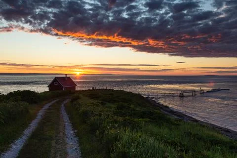 Dramatic sunrise view of small red cabin and wharf Stock Photos