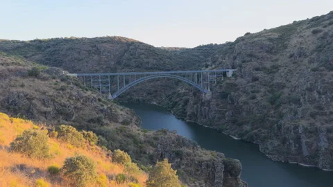 Dramatic Sunset Aerial of Metal Arch Bridge Over Deep River Canyon Stock Footage 329417434