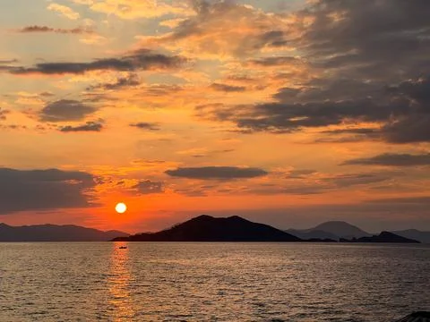 Dramatic sunset against the sea. Sunlight reflection Stock Photos