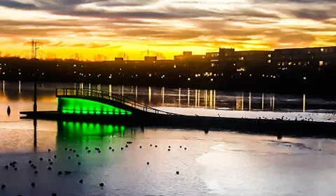 Dramatic sunset in Almere stad. The lake bridge house with green colour is al Stock Photos